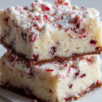 White chocolate peppermint cheesecake crinkle bars dusted with powdered sugar.