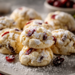 White Chocolate Cranberry Cream Cheese Crinkle Cookies dusted with powdered sugar on a a cooking paper